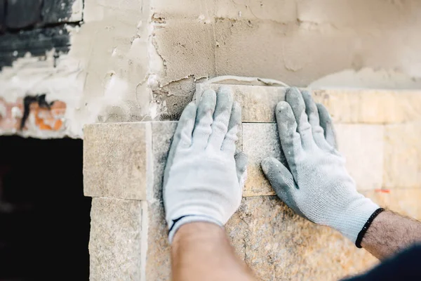 Detalles de las manos de los trabajadores de la construcción utilizando mortero y piedra para pavimentar paredes — Foto de Stock