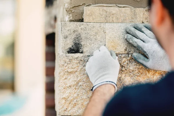 Trabalhador instalando superfície de parede de pedra com cimento para casa renovatin — Fotografia de Stock