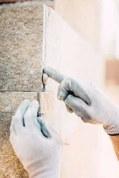 Zamknij Szczegóły rąk pracownika tynkowanie i ukladania kamienia na placu budowy. Szczegóły doskonałości w przemyśle budowlanym — Zdjęcie stockowe