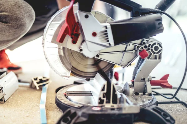 Homme, travailleur utilisant une scie à mitre composée coulissante avec lame circulaire pour couper le métal et l'aluminium — Photo