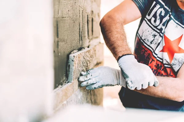 Constructor albañil construyendo una casa y pavimentando con piedra — Foto de Stock