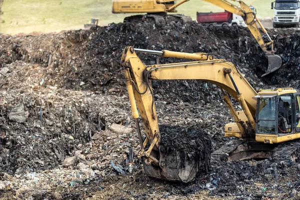 Monstro escavadora industrial cavar no lixo em terrenos de despejo urbano — Fotografia de Stock