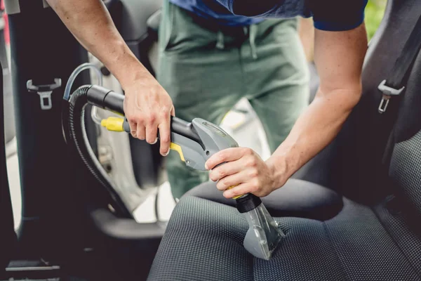 Detalhes da limpeza do carro macho usando vácuo a vapor profissional para o interior do carro sujo — Fotografia de Stock