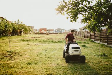 vintage effect of landscaping works. Male worker riding a tractor grass trimmer clipart