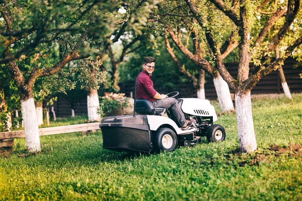 Çalışma ve Bahçe çim kesme gülümseyen gardner. Ayrıntılı peyzaj çim biçme makinesi ile çalışıyor — Stok fotoğraf