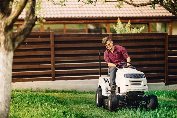 Lächelnder Arbeiter bei Garten- und Landschaftsbauarbeiten mit professionellen Werkzeugen und Maschinen — Stockfoto