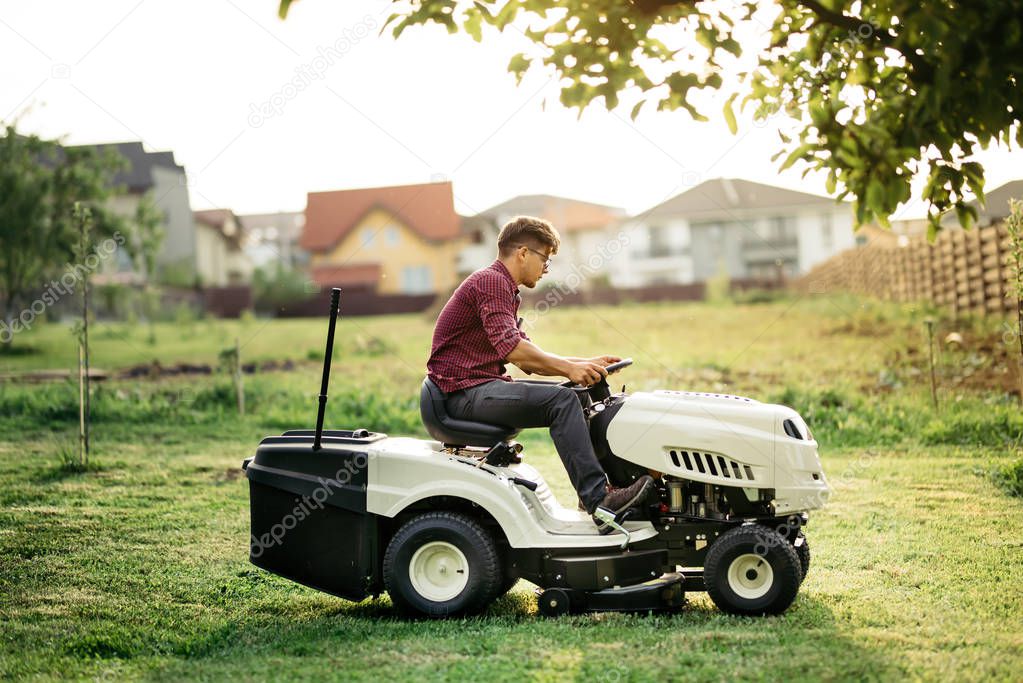 Garnder, man worker cutting grass with lawn mower, lawncare concept. Industrial details