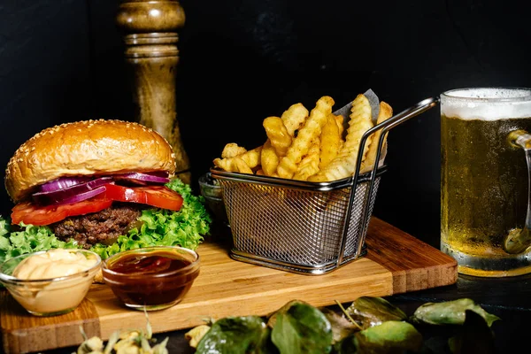 Leckere gegrillte Rindfleisch-Burger serviert mit Pommes und Salat auf Holzbrett in der örtlichen Kneipe — Stockfoto