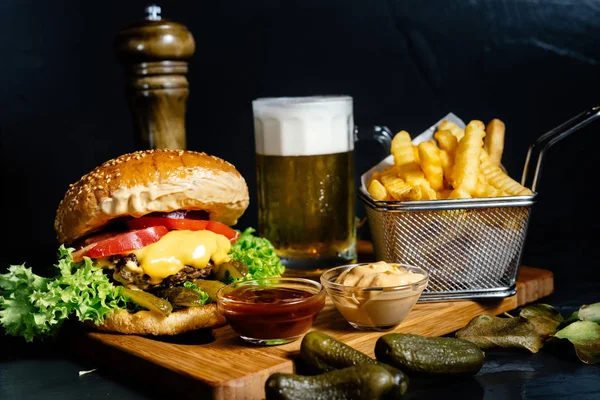 Köstliche saftige Cheeseburger mit Pommes, Gurken, Bier und Krautsalat serviert vom Bistro — Stockfoto