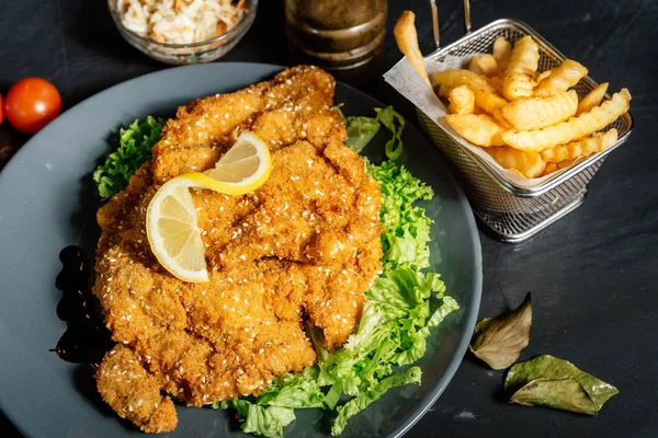 Details des köstlichen Abendessens - Pommes frites und Krautsalat mit gegrilltem Parmesan-Schnitzel — Stockfoto