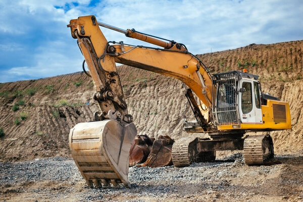 Industrial heavy duty excavator loading soil material from highway construction site 