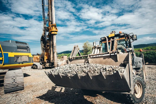Schwerlast-Bulldozer bewegt Kies auf Autobahnbaustelle. Mehrere Industriemaschinen auf Baustelle — Stockfoto