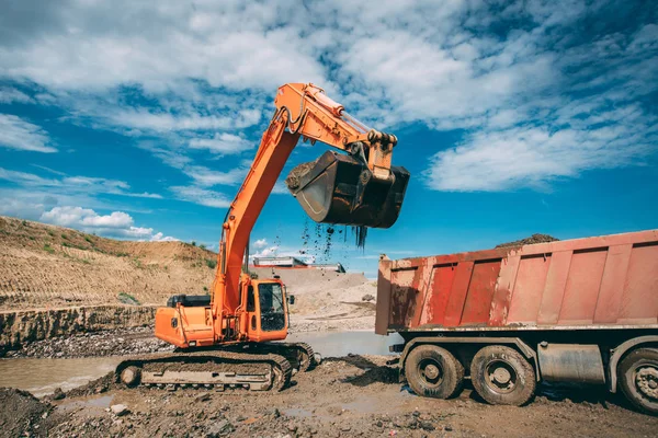 Escavadeira, bulldozer carregando caminhão basculante durante o local de construção da estrada — Fotografia de Stock
