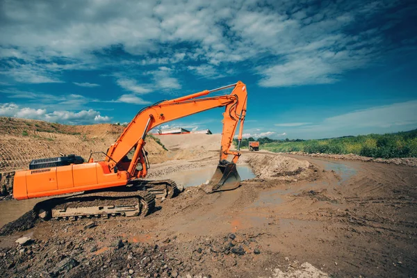 Industrial excavator working on highway construction site. Details of excavator digging in water and dirt for viaduct construction — Stock Photo, Image