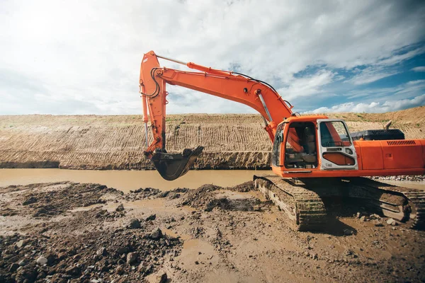 Heavy duty industrial excavator working during earthmoving works at highway construction site. Construction details