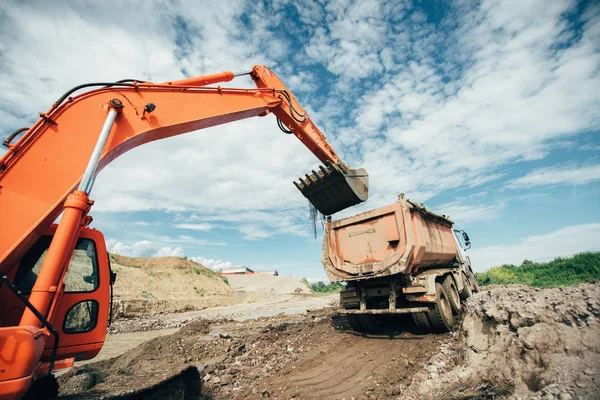 泥头车在公路施工现场过程中被加载。挖掘机铲做土方工程的详细信息。道路工程 — 图库照片