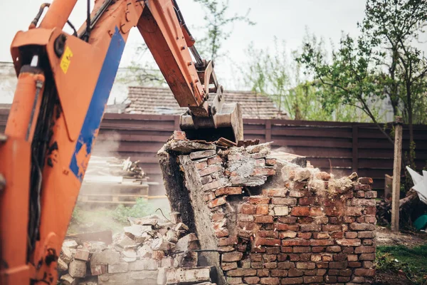 Pesado industrial retroescavadeira escavadeira e bulldozer demolir casa velha e ruínas — Fotografia de Stock