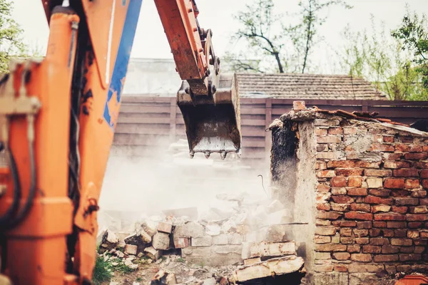 Industrial close up of excavator using scoop for demolishing old house and ruins — Stock Photo, Image