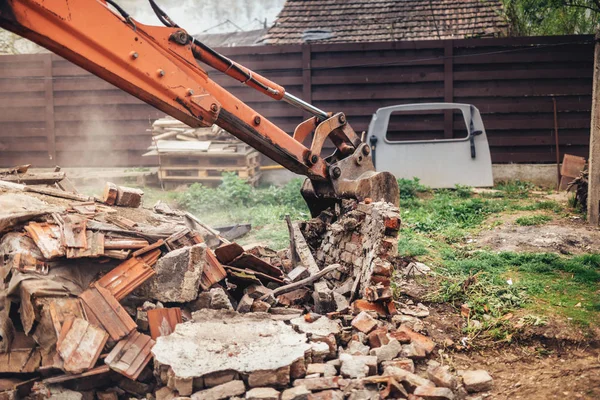 Detalles del sitio de construcción industrial con excavadora utilizando cuchara para demoler y destruir la antigua casa — Foto de Stock