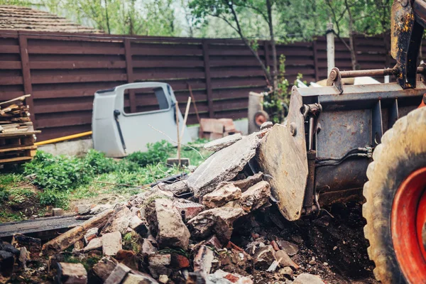 Graafmachine, bulldozer op sloop site laden bakstenen- en betonnen muren — Stockfoto