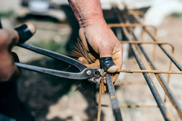 Barras de armadura no canteiro de obras, mãos do construtor, trabalhador da construção no local — Fotografia de Stock