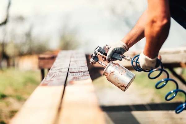 Man schilderen houten hout met bruine kleur tijdens renovatie werkt — Stockfoto