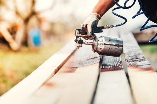 Gros plan d'un travailleur industriel utilisant un pistolet à peinture ou un pistolet pulvérisateur pour appliquer de la peinture — Photo