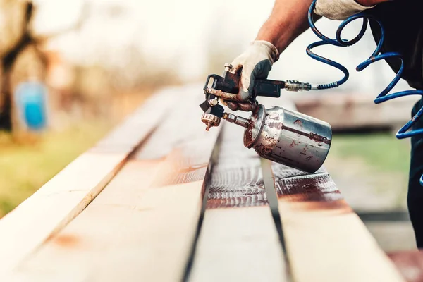 Industrial handyman, construction worker painting with spray gun on site. Construction details — Stock Photo, Image