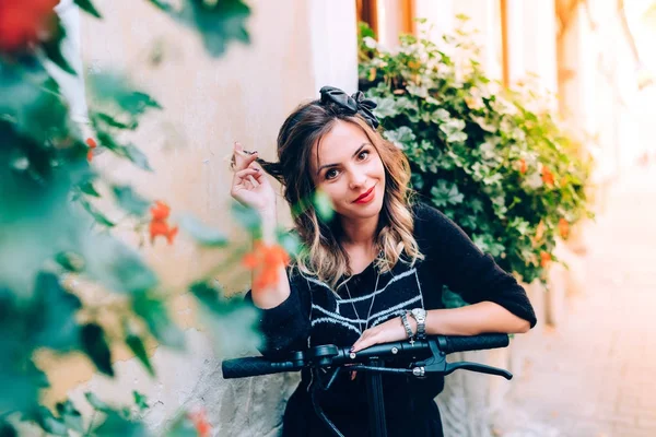 Femme gaie jouissant d'un style de vie moderne dans un paysage urbain entouré de fleurs — Photo