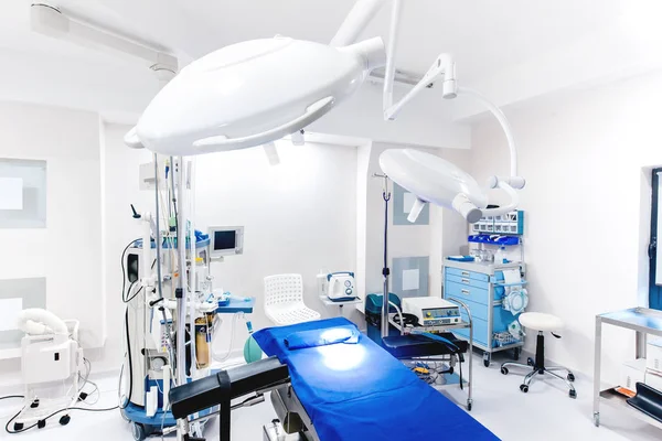 Εσωτερικό σύγχρονο νοσοκομείο. Καταχώρηση ιατρικού εξοπλισμού με λάμπες και χειρουργικό τραπέζι — Φωτογραφία Αρχείου