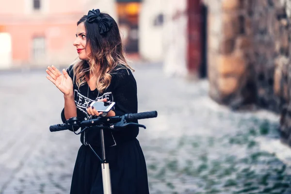 Giovane bella donna sorridente alla macchina fotografica, in posa e godersi una serata rilassante sulle strade della città — Foto Stock