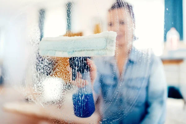 Portret kobiety robi sprzątanie działa z bliska. Młoda kobieta przy użyciu okna czyszczenia i robienie prac domowych w domu — Zdjęcie stockowe