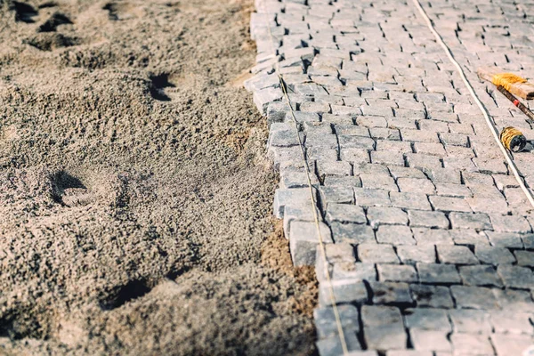 Arnavut kaldırımlı avenue Yükleme ayrıntıları. Yol kaldırım granit taş ile yaşayan engeller — Stok fotoğraf