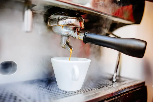 Cafetera espresso vertiendo café en tazas, capuchino y café en la cafetería —  Fotos de Stock