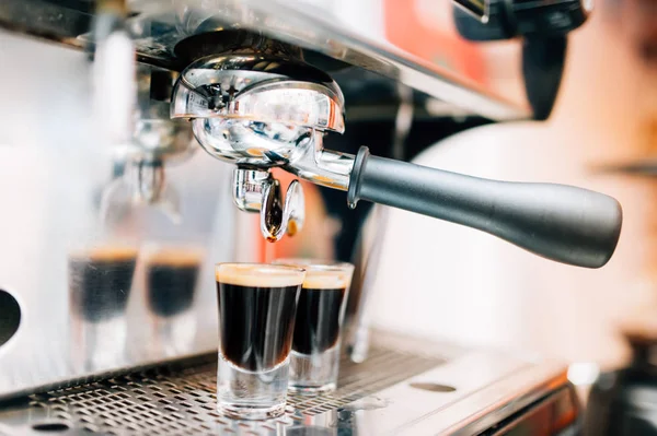 Närbild på espresso maskin hälla nybryggt kaffe i koppar på restaurang — Stockfoto