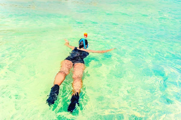 Jonge vrouw snorkelen in een tropische zee in de buurt van zandstrand — Stockfoto