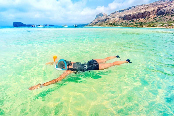 Fekvő nő élvezi süt a nap, a strand visel a snorkeling maszk, búvárkodni és úszni a tengerben — Stock Fotó