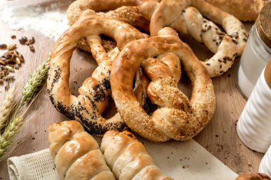 Susamlı simit ve ahşap arka plan üzerinde farklı ekmek yapım ürünleri