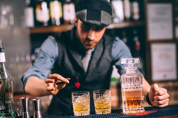 Perfect bartender garnishing drinks and whiskey cocktails at modern bar — Stock Photo, Image