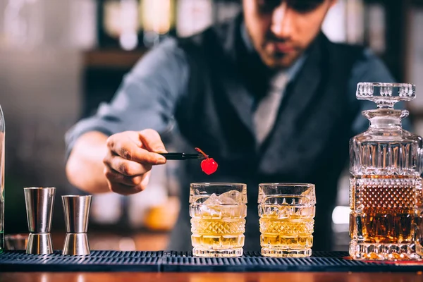 Close up of bartender hands preparing old fashioned whiskey cocktail on bar counter — Stock Photo, Image