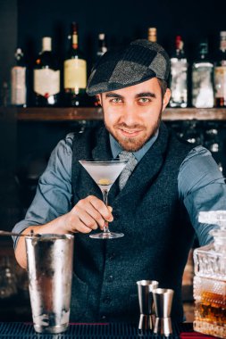 Sek martini hazırlamak ve müşterilerine hizmet veren yakışıklı, vintage barmen. 