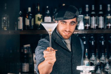 hazırlama ve sek martini kokteyl martini cam içinde hizmet veren barmen. kokteyl ve arka plan bar üzerinde barmen