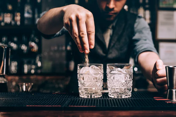 Close up of barman hands pouring sugar in old fashioned cocktail. fresh beverages at bar — Stock Photo, Image