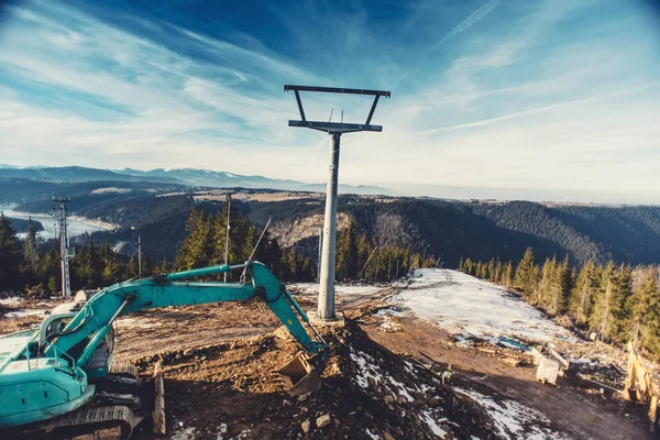 工业挖掘机在高山滑雪区的建筑斜坡上工作 — 图库照片