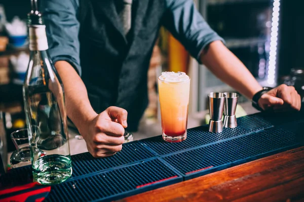 Porträt eines eleganten Barkeepers, der Orangen-Wodka und Tequila-Cocktails zubereitet — Stockfoto