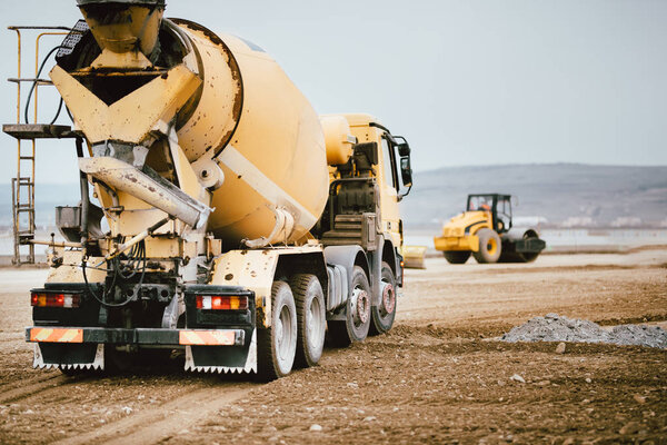 Industrial Cement truck on highway construction site. Heavy duty machinery at work on construction site