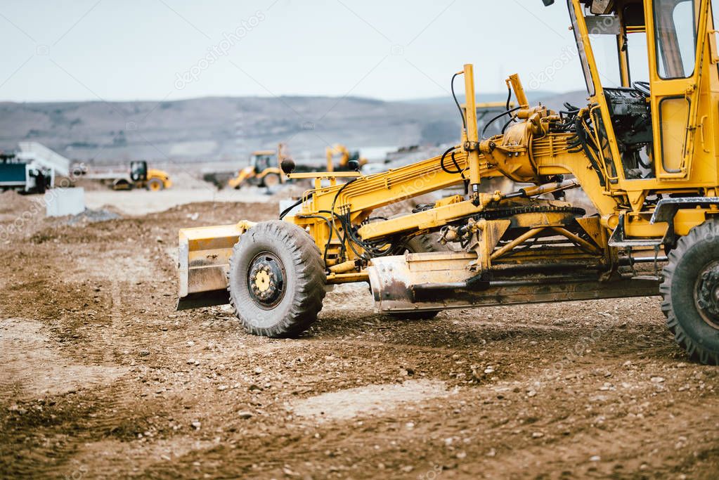 Industrial road construction site, highway building. Heavy duty machinery working on site