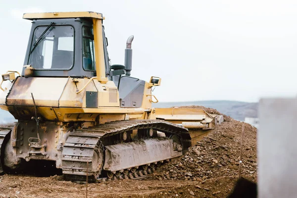 Local de construção industrial bulldozer amarelo nivelamento e solo em movimento durante a construção de rodovias — Fotografia de Stock