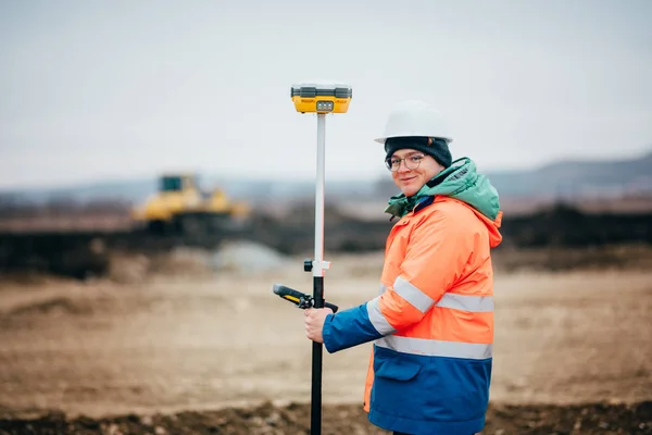 Engenheiro de vistoria trabalhando no canteiro de obras da rodovia, trabalhando com teodolita e sistema de GPS — Fotografia de Stock