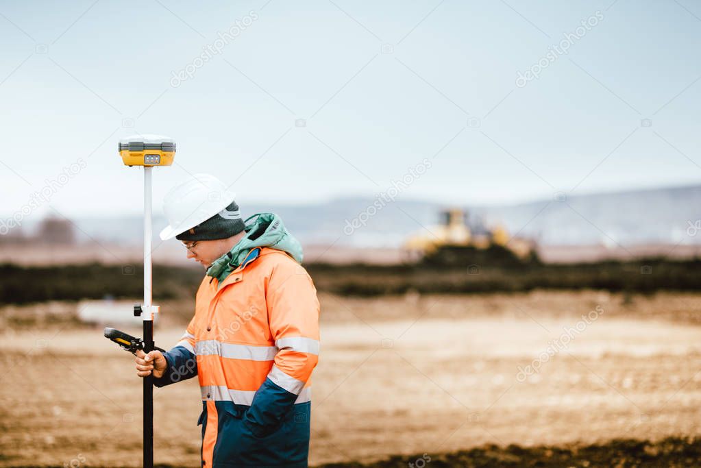 Surveyor engineer working with technology for coordinating heavy duty machinery